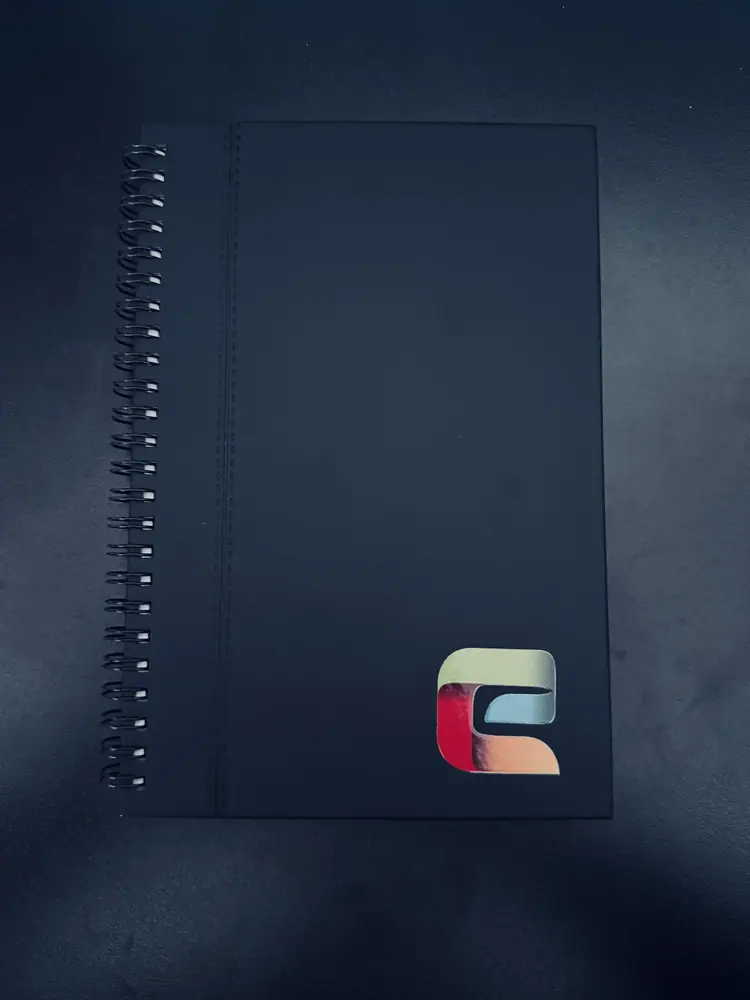 Libreta de espiral negra con logo a color en la esquina